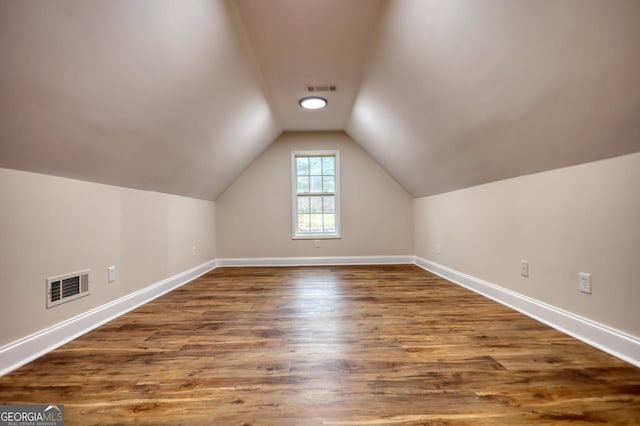 additional living space with lofted ceiling and wood-type flooring