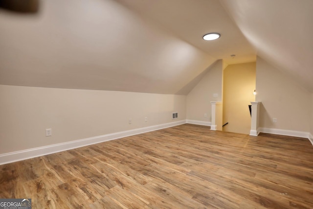 bonus room with wood-type flooring and lofted ceiling