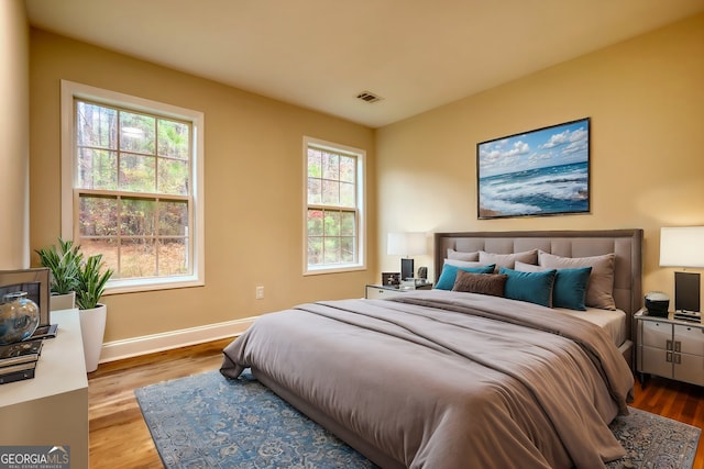 bedroom featuring hardwood / wood-style floors and multiple windows