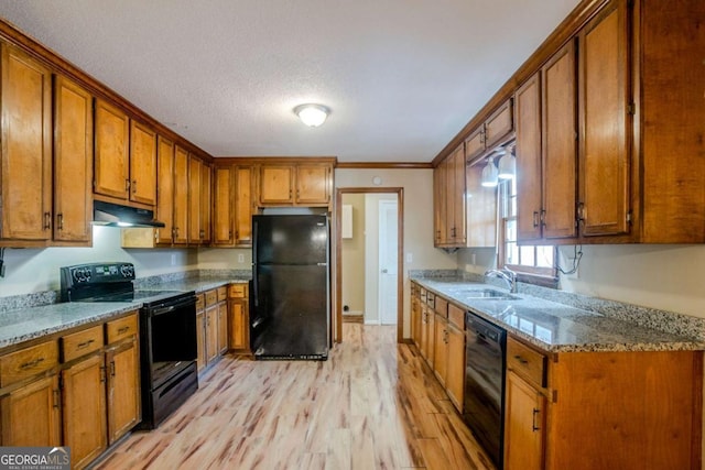 kitchen featuring light stone countertops, sink, light hardwood / wood-style flooring, crown molding, and black appliances