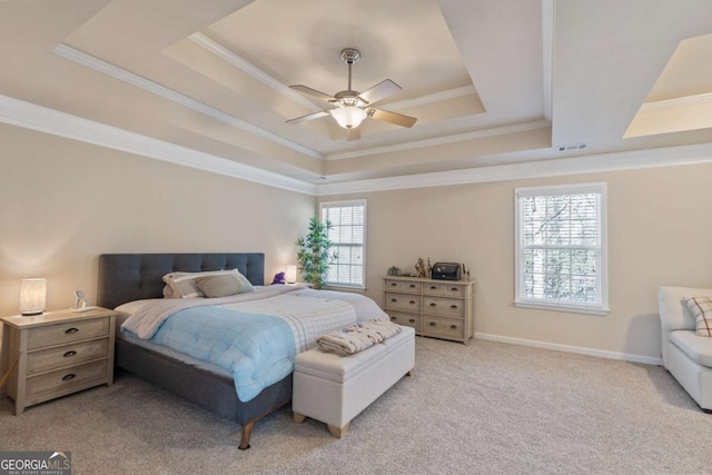 bedroom with ceiling fan, light colored carpet, a tray ceiling, and multiple windows