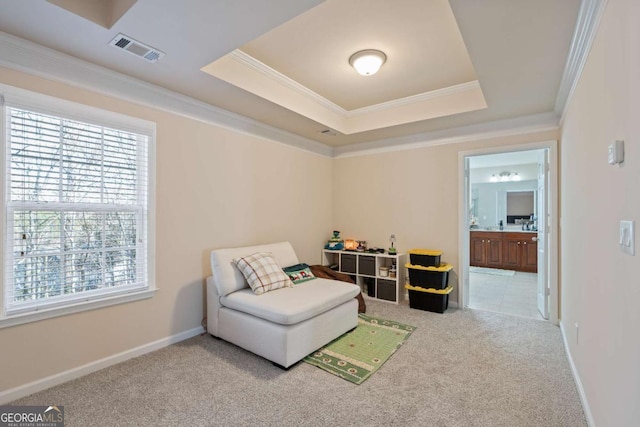 sitting room with a raised ceiling, light colored carpet, and ornamental molding