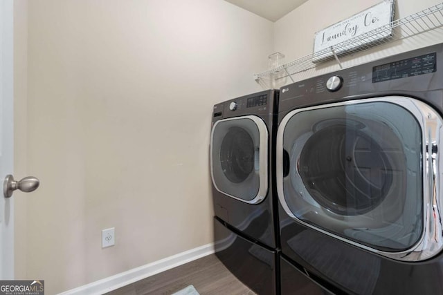 laundry room featuring washer and dryer and dark wood-type flooring