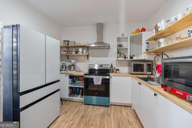 kitchen featuring wall chimney exhaust hood, white cabinetry, stainless steel appliances, and light hardwood / wood-style flooring