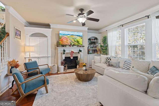 living room with hardwood / wood-style floors, ceiling fan, and crown molding