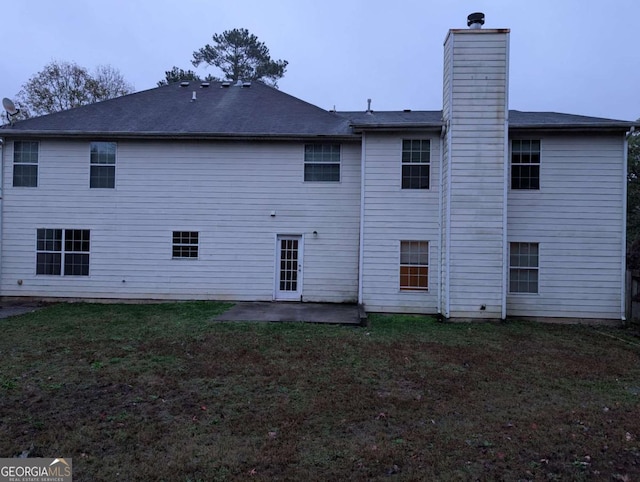 back of house featuring a lawn and a patio