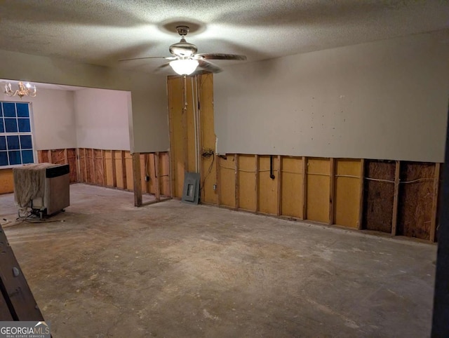 empty room with ceiling fan and a textured ceiling