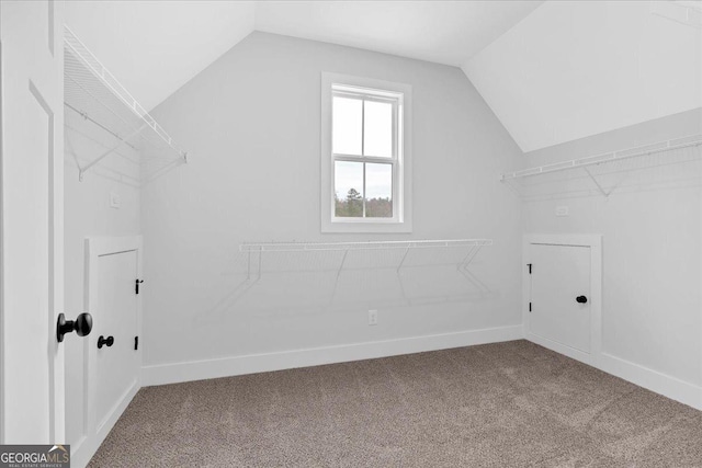 interior space with carpet flooring and vaulted ceiling