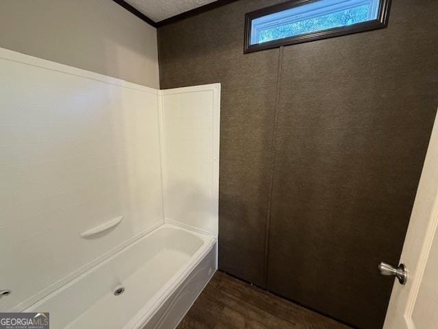 bathroom with hardwood / wood-style floors and bathing tub / shower combination