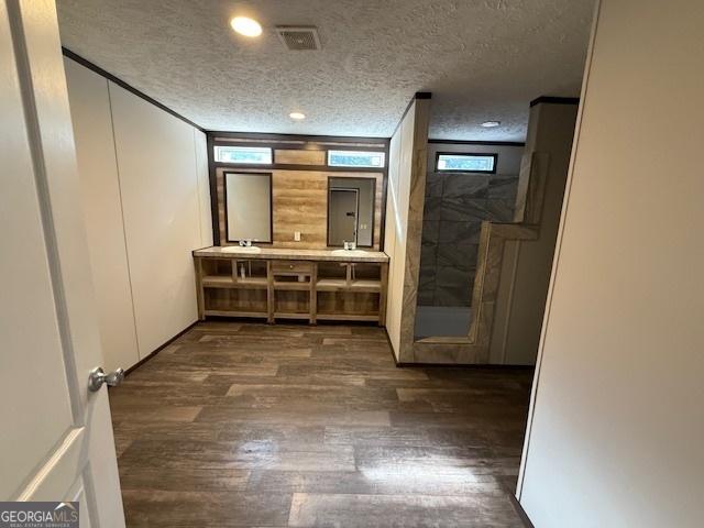 hall featuring crown molding, dark hardwood / wood-style flooring, and a textured ceiling