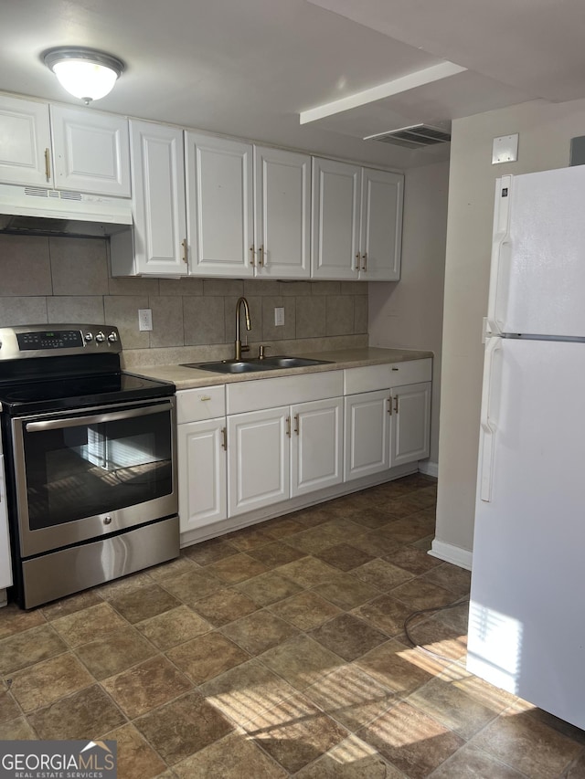 kitchen with white cabinets, white refrigerator, sink, stainless steel electric range oven, and tasteful backsplash