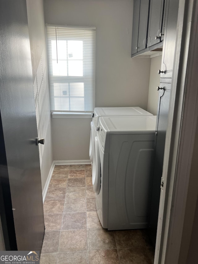 clothes washing area featuring cabinets and washing machine and clothes dryer