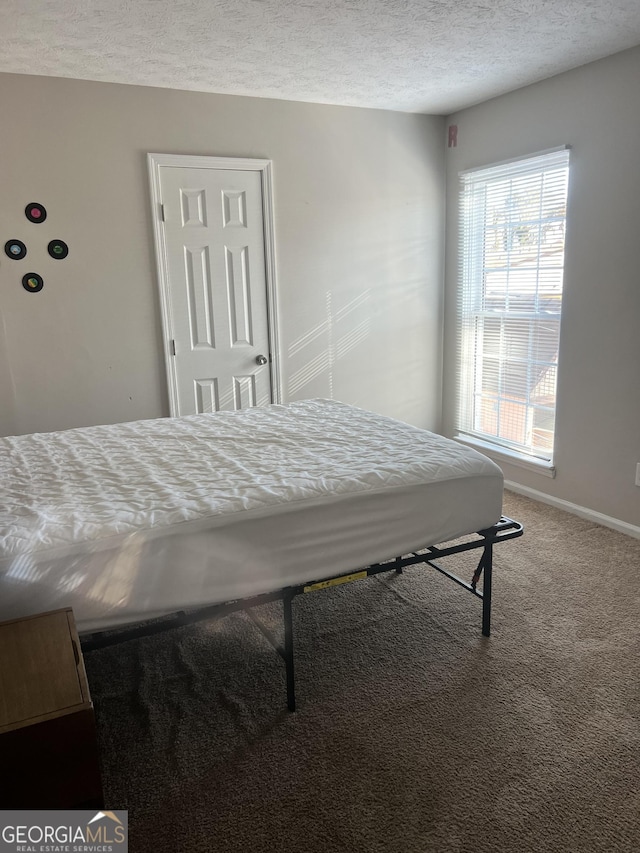 bedroom featuring carpet and a textured ceiling