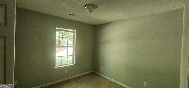 unfurnished room featuring a textured ceiling