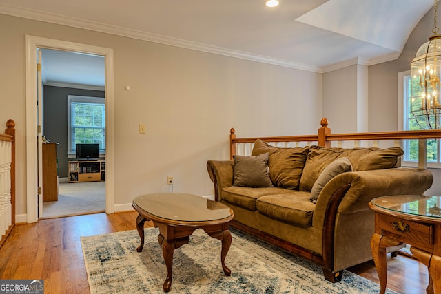 living room featuring ornamental molding, light hardwood / wood-style floors, and a notable chandelier