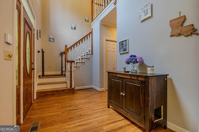 foyer featuring a high ceiling and light hardwood / wood-style flooring