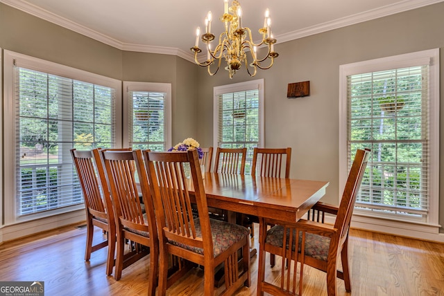 dining room with an inviting chandelier, light hardwood / wood-style floors, and ornamental molding