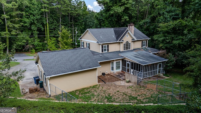 rear view of property featuring a sunroom