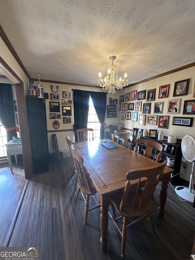 dining area featuring hardwood / wood-style floors, a chandelier, a textured ceiling, and ornamental molding