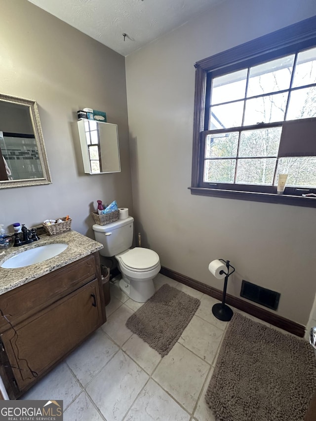 bathroom with tile patterned flooring, vanity, and toilet