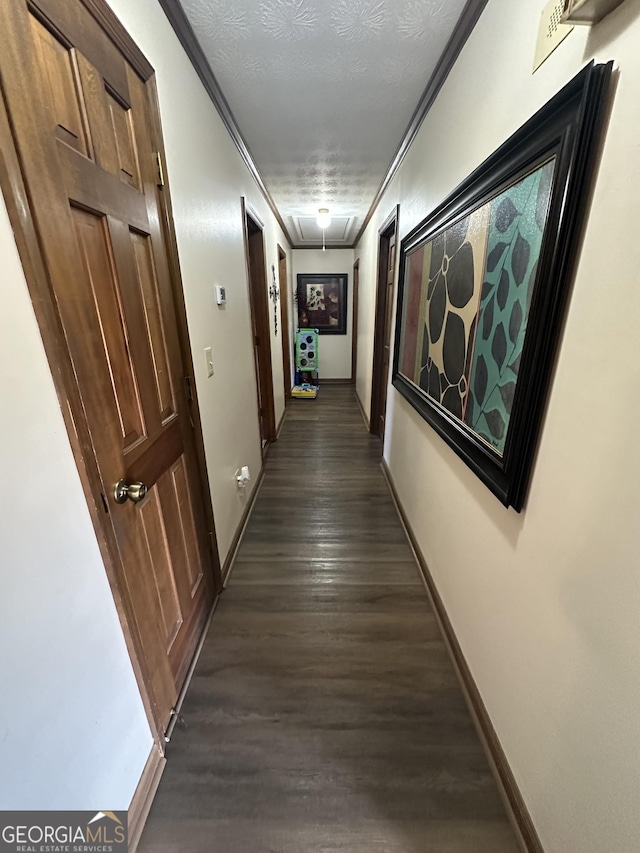 hall with dark hardwood / wood-style floors, crown molding, and a textured ceiling