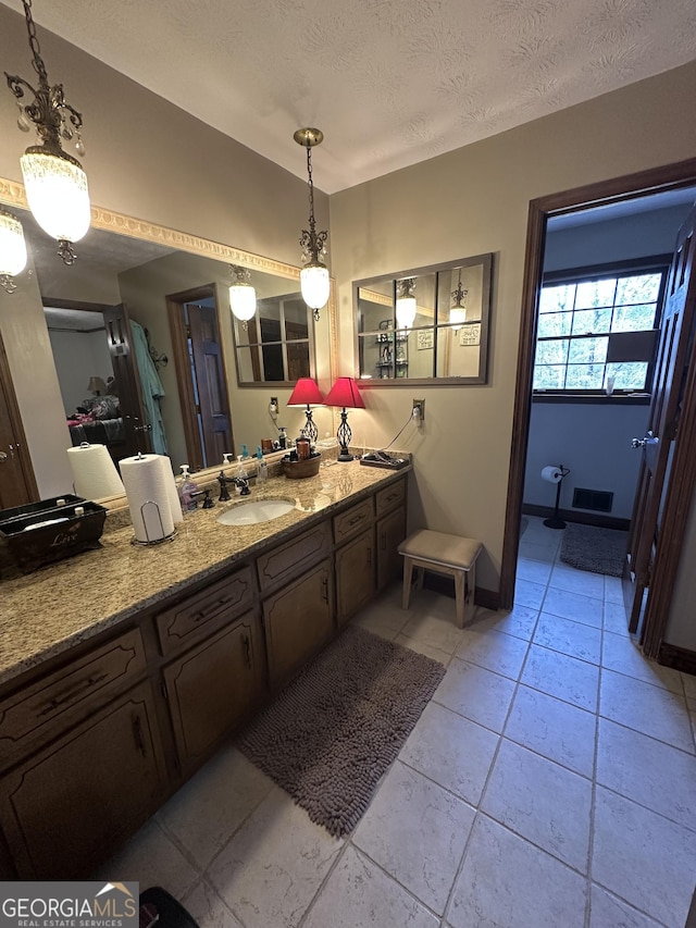 bathroom featuring tile patterned flooring, vanity, and a textured ceiling