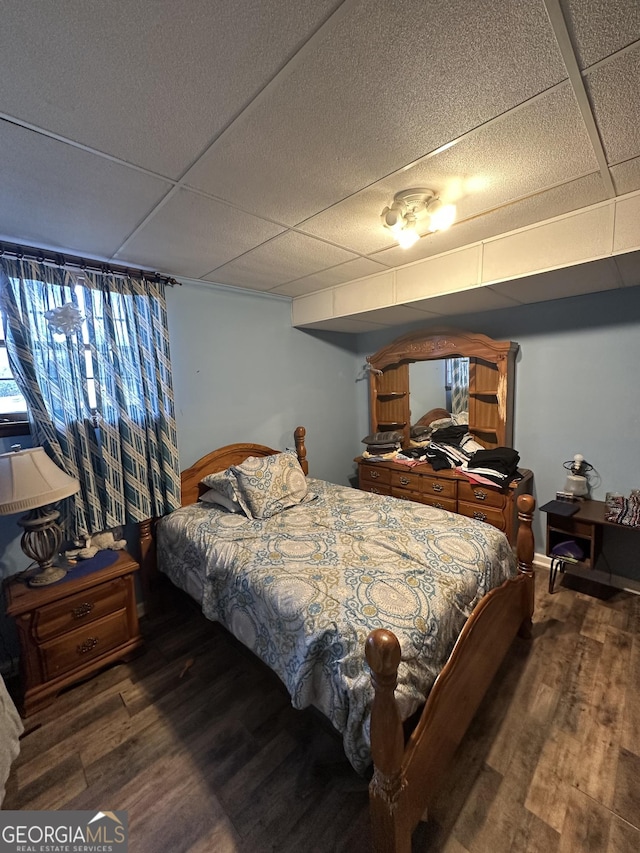 bedroom featuring a paneled ceiling and dark wood-type flooring