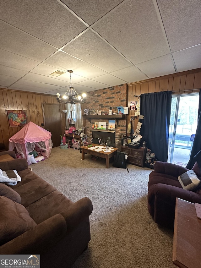 living room featuring wooden walls, carpet floors, and an inviting chandelier