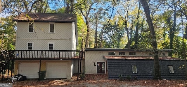 back of house with a garage and a deck