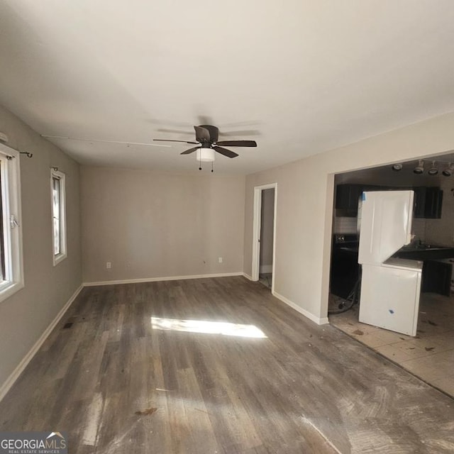 unfurnished living room featuring dark hardwood / wood-style floors and ceiling fan