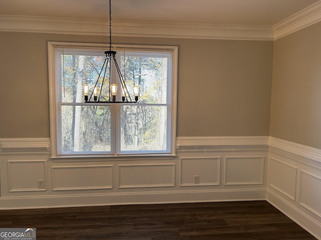 unfurnished dining area featuring ornamental molding, dark wood-type flooring, and an inviting chandelier