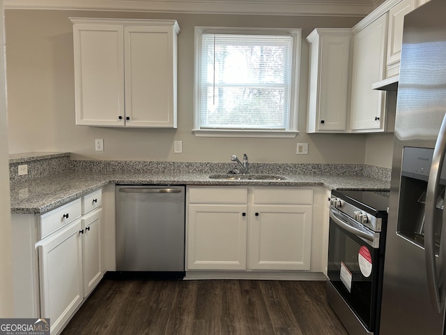 kitchen with light stone countertops, white cabinetry, sink, stainless steel appliances, and dark hardwood / wood-style flooring