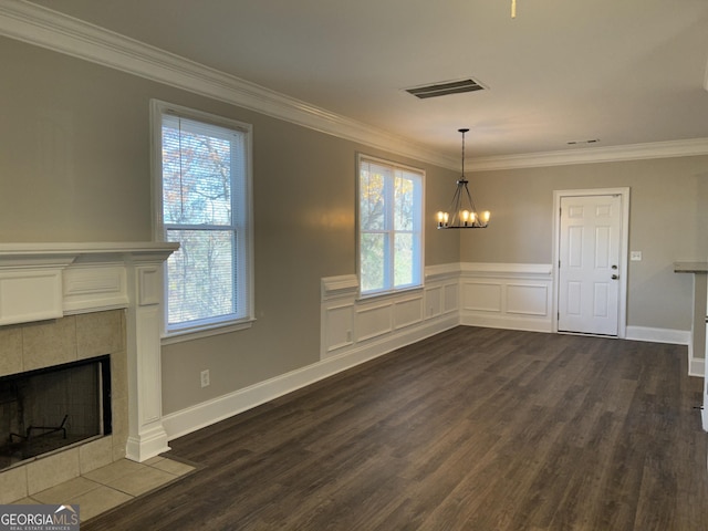 unfurnished dining area featuring plenty of natural light, a chandelier, dark hardwood / wood-style floors, and ornamental molding