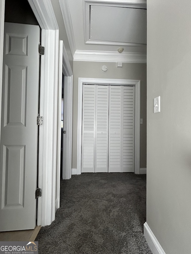 hallway with dark colored carpet and ornamental molding