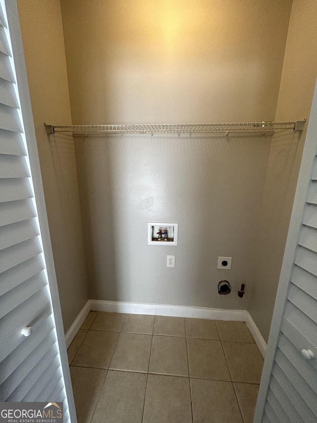 clothes washing area featuring electric dryer hookup, hookup for a washing machine, and light tile patterned floors