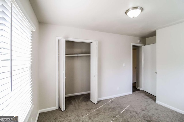 unfurnished bedroom featuring light carpet and a closet