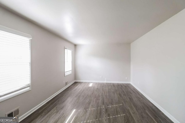 spare room featuring dark wood-type flooring