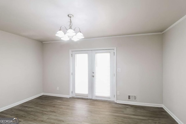 spare room featuring a chandelier, french doors, dark hardwood / wood-style floors, and ornamental molding