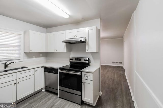 kitchen with white cabinets, appliances with stainless steel finishes, light hardwood / wood-style flooring, and sink