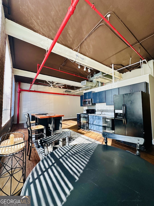 interior space with black fridge and wood-type flooring