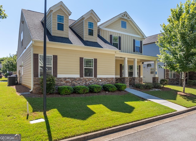 view of front of home with central air condition unit and a front yard