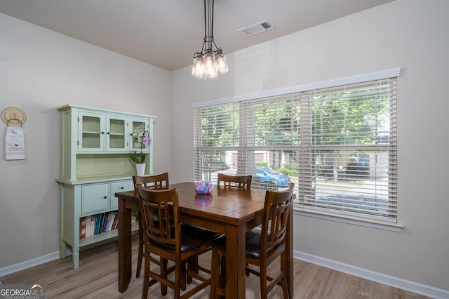 dining space with a notable chandelier and light wood-type flooring