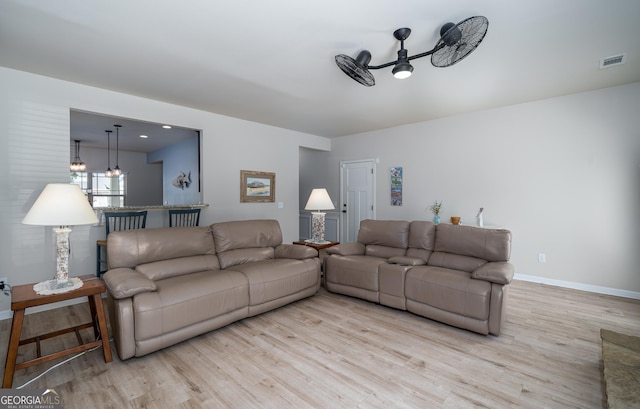 living room with ceiling fan and light hardwood / wood-style floors