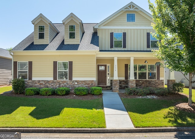 craftsman-style home featuring a front lawn and covered porch