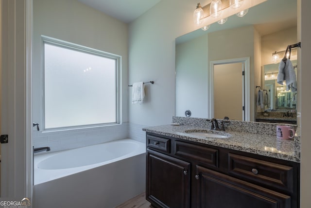 bathroom featuring a bathing tub, vanity, and hardwood / wood-style flooring