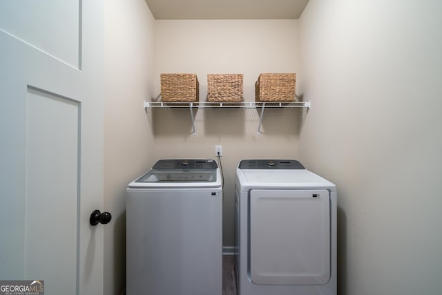 washroom featuring hardwood / wood-style flooring and washing machine and dryer