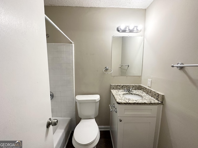 full bathroom with vanity, tiled shower / bath combo, a textured ceiling, and toilet