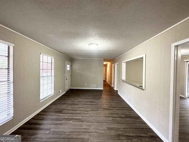 interior space featuring dark hardwood / wood-style floors, ornamental molding, and a textured ceiling