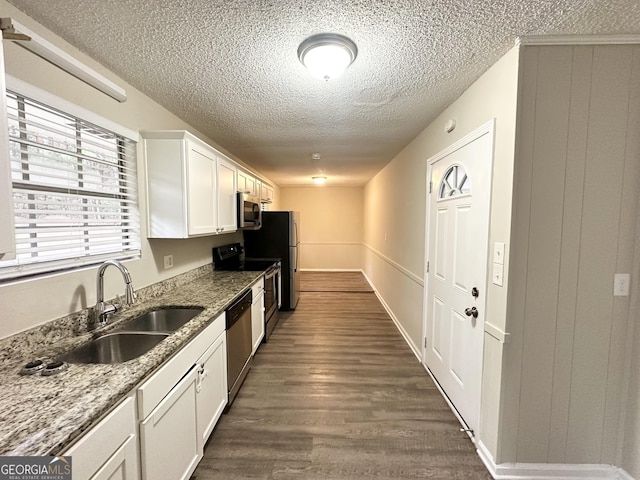 kitchen featuring white cabinets, sink, dark hardwood / wood-style floors, light stone countertops, and appliances with stainless steel finishes