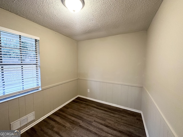 spare room with dark hardwood / wood-style flooring and a textured ceiling